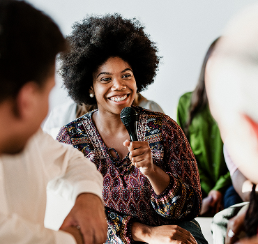 cheerful-woman-speaking-on-a-microphone-in-a-works-2025-02-09-23-56-31-utc-1.jpg